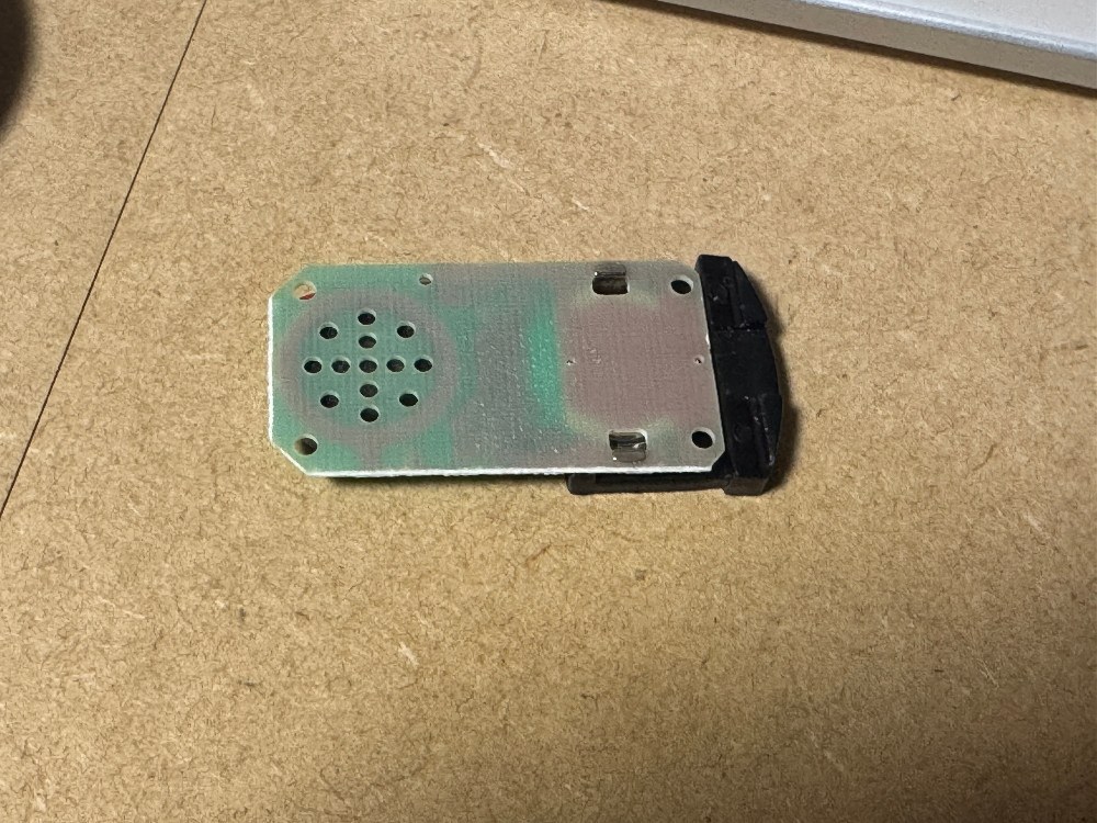 引き上げた時の画像。基盤の裏側に糊が付着。これで交換不可能ということになっている。左側の花火みたいな穴はスピーカー。