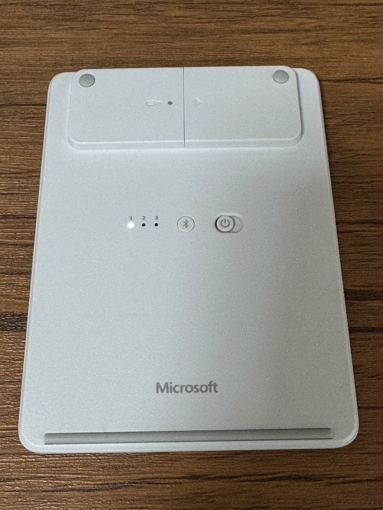 本体裏面。上部に電池。中央にBluetooth切り替えボタン。その右は電源スイッチ。